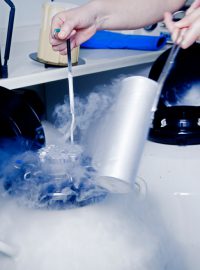 Scientist opening a cryopreservation tank, used to put living cells in a state of suspended animation in ultra low temperatures.
