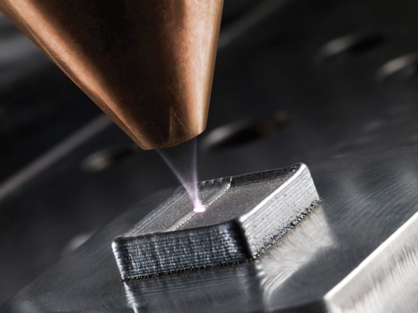 3D printer creating metal part in additive manufacturing.